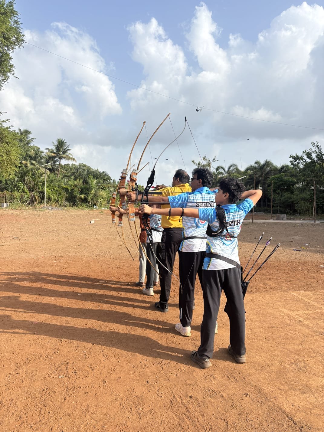 A group of archers holding bows on a practice range